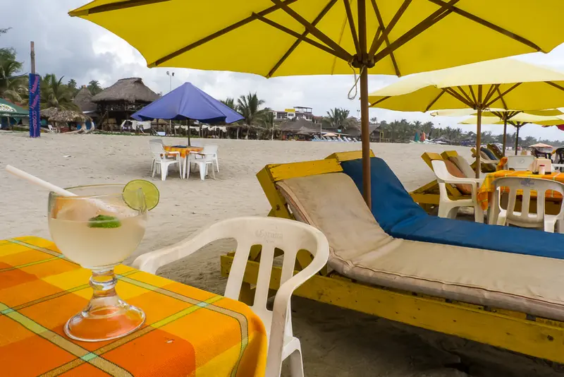 Parasols jaunes et tables face à la mer sur la Playa Zicatela, Puerto Escondido